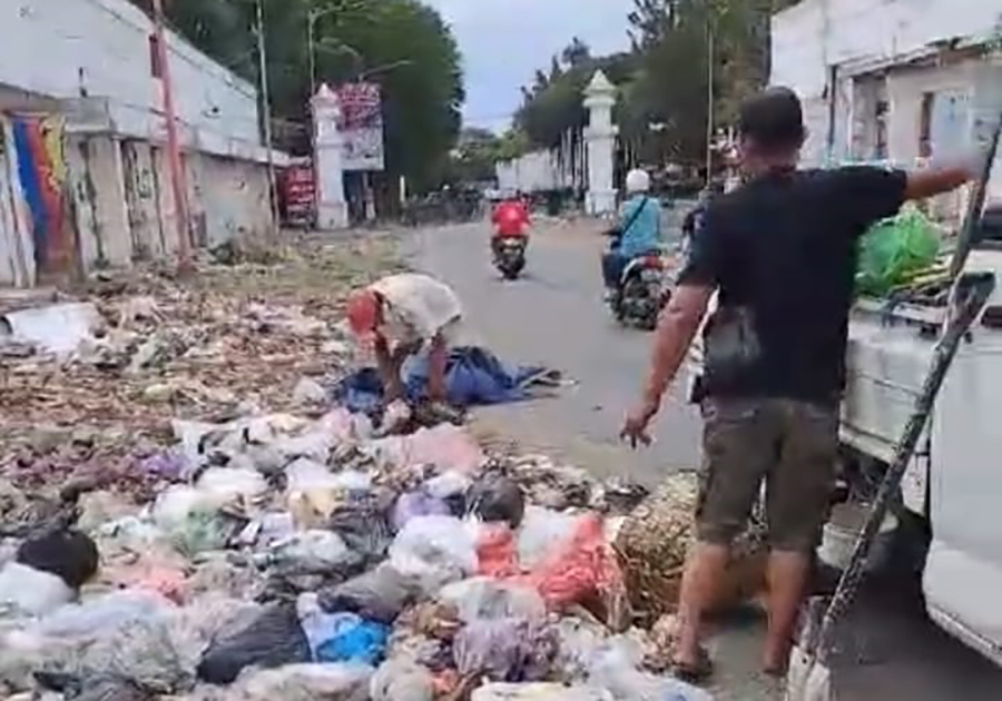 BERSERAKAN: Petugas DLH mengangkut sampah yang dibuang oleh orang yang tidak bertanggung jawab di pinggir jalan kawasan Pasar Banyuwangi, Senin (16/9).