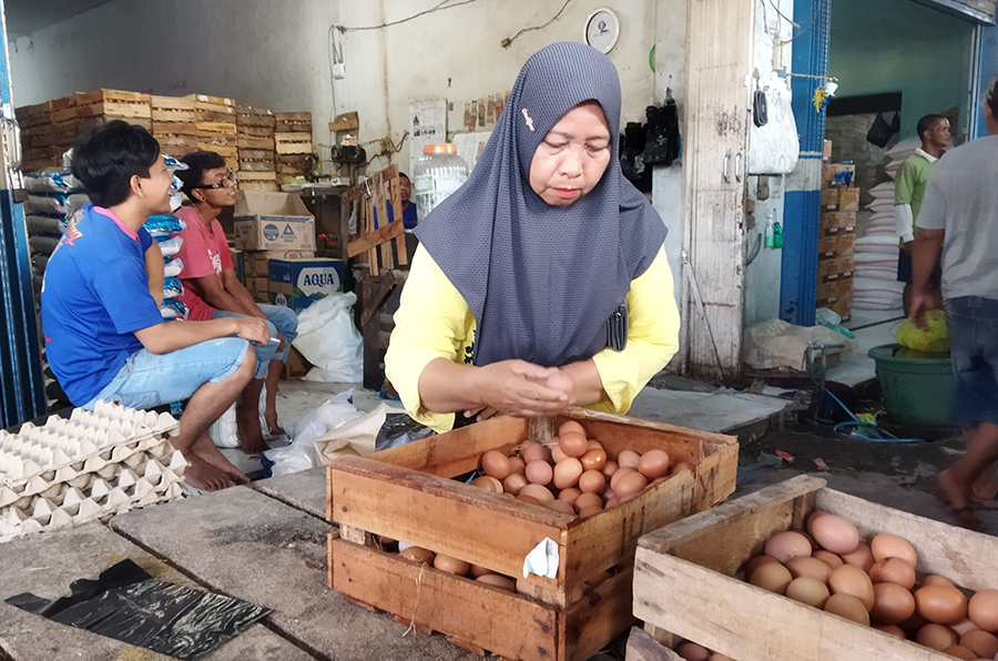 BELANJA: Konsumen memilih telur yang akan dibeli di salah satu agen sembako di sekitar Pasar Banyuwangi, Selasa (17/9).
