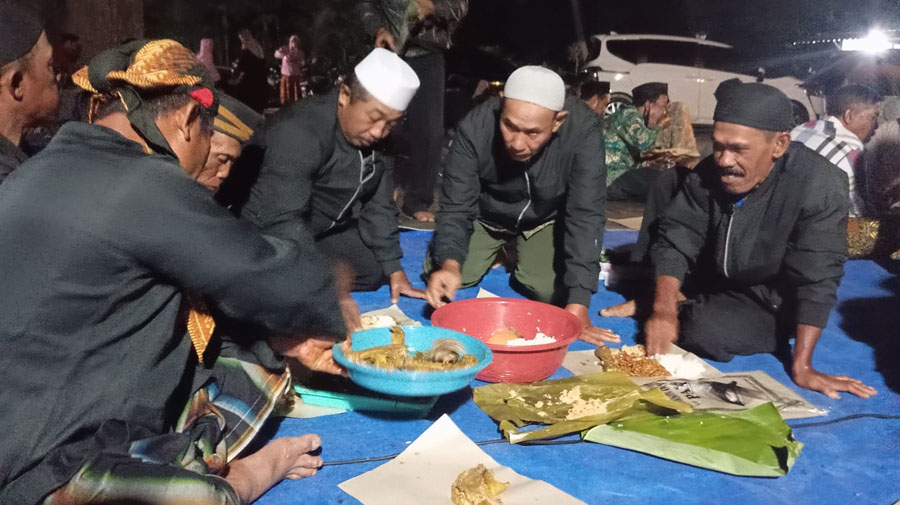 SYUKURAN: Warga menyantap nasi ingkung usai ritual padang bulan di Petilasan Mbah Kopek di Dusun Sumberjoyo, Desa Kumendung, Kecamatan Muncar pada Selasa (17/9) malam.