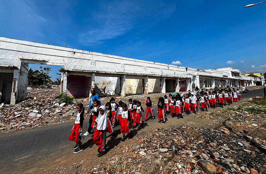 SEGERA DIREVITALISASI: Rombongan pelajar SD melintas di kawasan Pasar Banyuwangi. Bangunan sisi utara dan selatan sudah dikosongkan, Jumat (20/9).