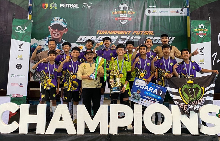 Tim futsal MTsN 1 Banyuwangi berfoto sembari menunjukkan piala usai menjuarai Dandim Cup 2024 di lapangan indoor GOR Tawangalun, Sabtu (21/9) malam.