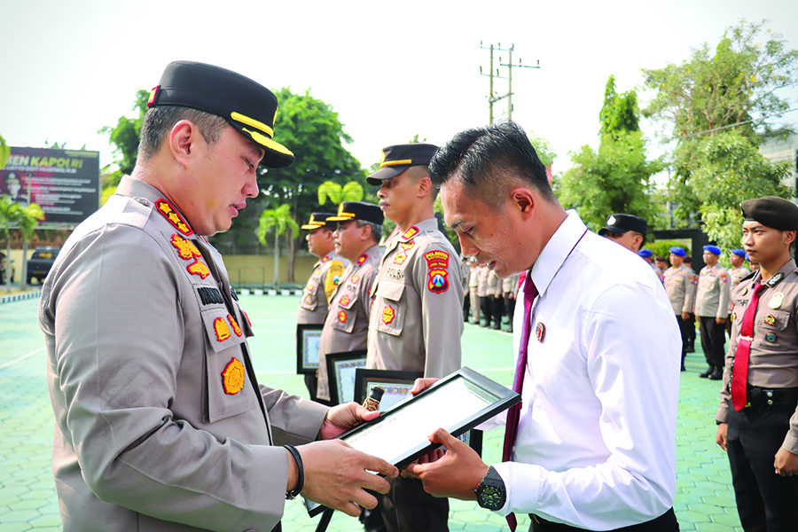 PRESTASI: Kanit Reskrim Polsek Muncar Ipda Ocky Heru Prasetyo menerima penghargaan dari Kapolresta Banyuwangi Kombespol Nanang Hariyono di Mapolresta Banyuwangi, Senin (23/9