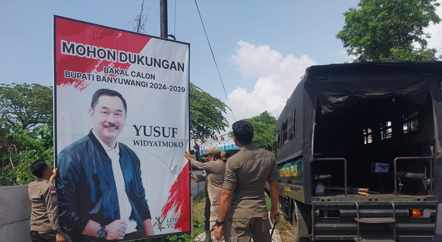 DITERTIBKAN: Petugas Satpol PP membongkar sejumlah reklame bakal cabup-cawabup yang masih terpasang di sejumlah titik di Banyuwangi, Selasa (24/9).