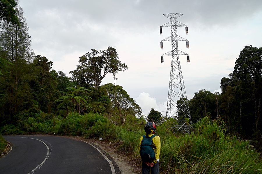 PROYEK FISIK: Aktivitas pekerja merampungkan pembangunan tower SUTET bisa dilihat dari tepi jalan menuju Paltuding.