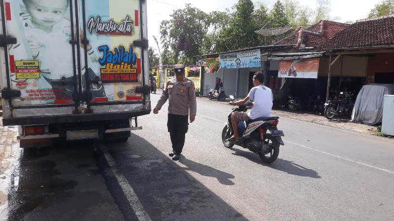 TERPARKIR: Anggota Lantas Polsek Gambiran mengecek lokasi truk boks yang ditabrak Vina Duratun Munawaroh di Jalan Soekarjo, Dusun Krajan, Desa/Kecamatan Pesanggaran Rabu (2/10).
