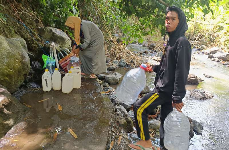 SESUAI URUTAN: Warga harus antre untuk mengambil air siap minum di sumber Dusun Pekiringan, Desa Sumbersari, Kecamatan Srono Minggu (6/10)