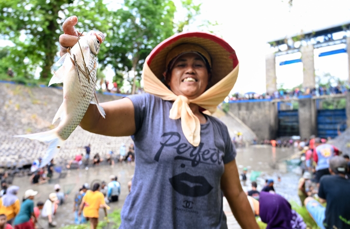 AKU DAPAT!: Warga di wilayah Kecamatan Muncar, Banyuwangi, turun ke sungai untuk berburu ikan saat pengeringan Dam Singir Mangunrejo, Desa Blambangan, Selasa (15/10).