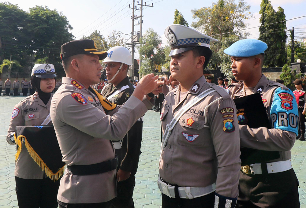 Kapolresta Banyuwangi Kombespol Rama Samtama Putra menyematkan pita kepada personel Operasi Zebra Semeru di Mapolresta Banyuwangi, Senin (14/10).