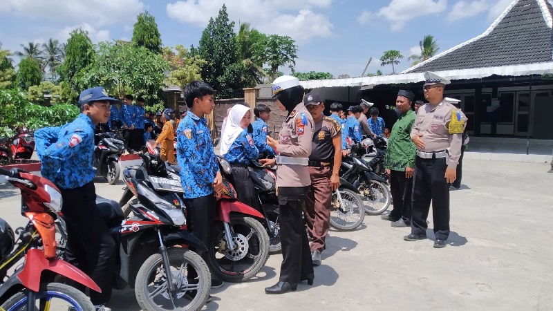 TIDAK STANDAR: Ipda Enita Dwi Rahayu mengecek puluhan kendaraan siswa yang terjaring razia di SMPN 3 Genteng Rabu (16/10).
