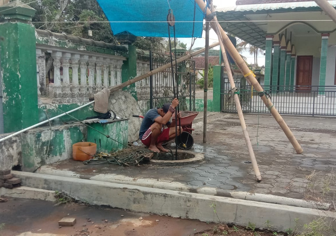 SULIT AIR: Sugi Handoko melihat sumur di rumahnya yang mengering dampak kemarau berkepanjangan di Dusun Blangkon, Desa Kebaman, Kecamatan Srono Kamis (24/10).