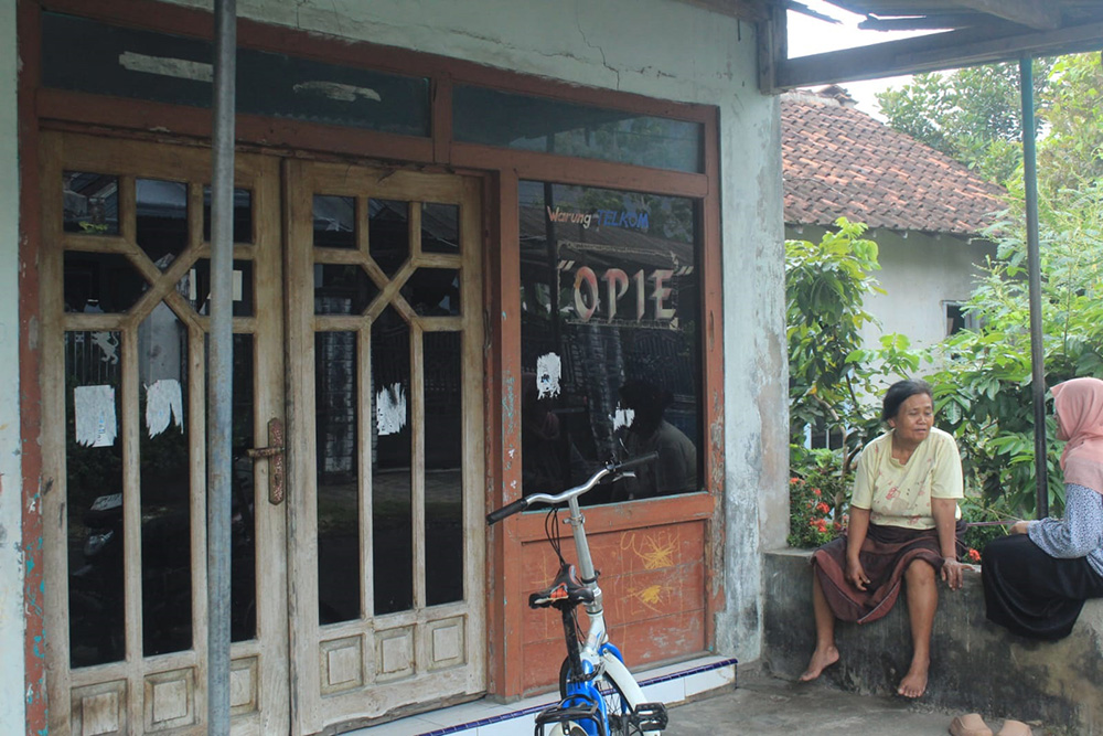 KACA PINTU PECAH: Anna (kiri) dengan warga di teras rumahnya dengan kaca jendela rumah yang masih bolong akibat aksi teror pecah kaca, Jumat (8/11).