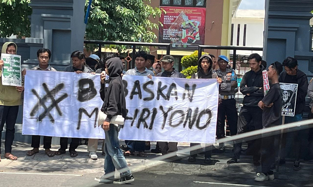 DIJAGA POLISI: Pendukung Muhriyono menggelar orasi di depan kantor Pengadilan Negeri Banyuwangi.