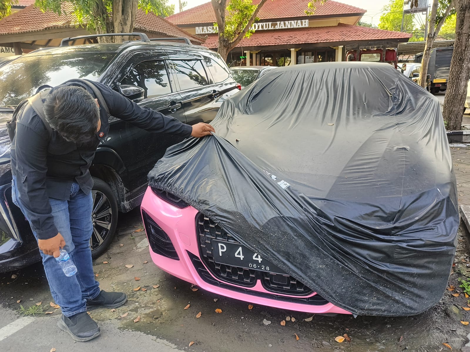 BUKAN WARNA ASLI: Mobil BMW warna pink dengan nopol P 44 PII milik Murni Abdullah masih diamankan di Mapolresta Banyuwangi, Minggu (10/11).
