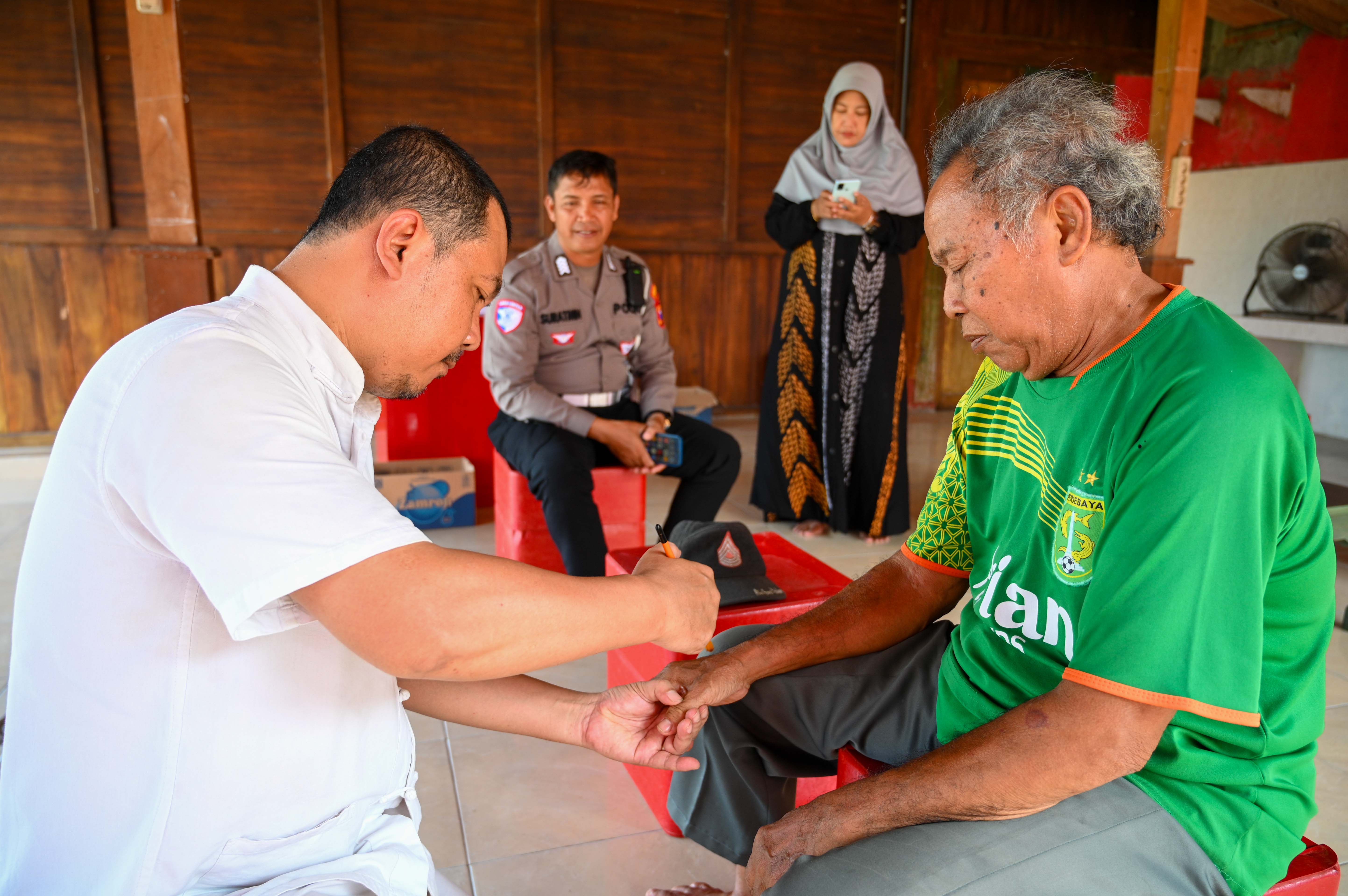 BERI LAYANAN: Sinshe Acong menangani pasien di kompleks Masjid Haji Muhammad Cheng Hoo Banyuwangi pada Selasa (12/11).