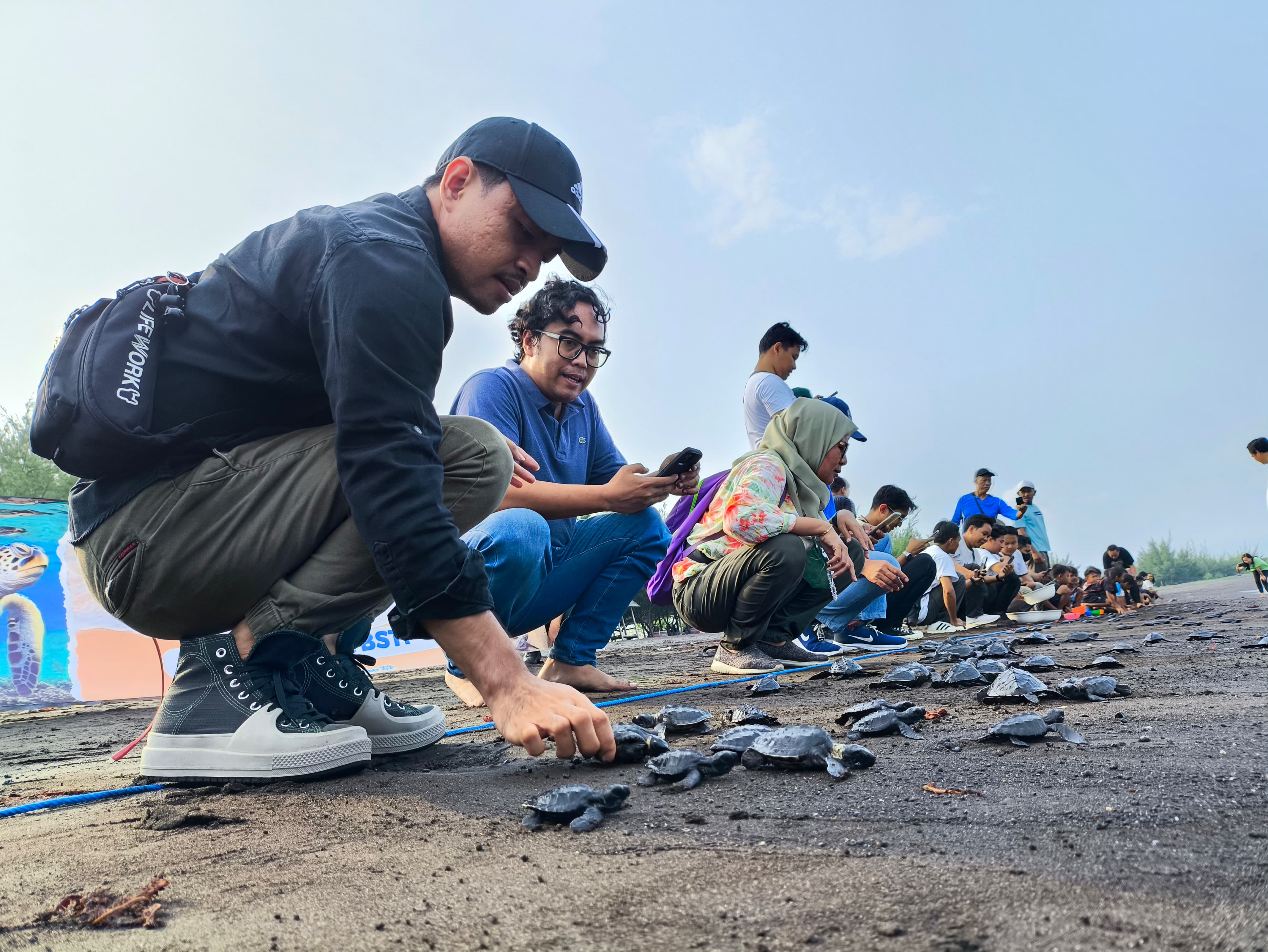Indofood, BSTF, dan anak-anak melepaskan tukik penyu lekang di Pantai Pulau Santen, Kelurahan Karangrejo, Banyuwangi, Kamis (14/11).