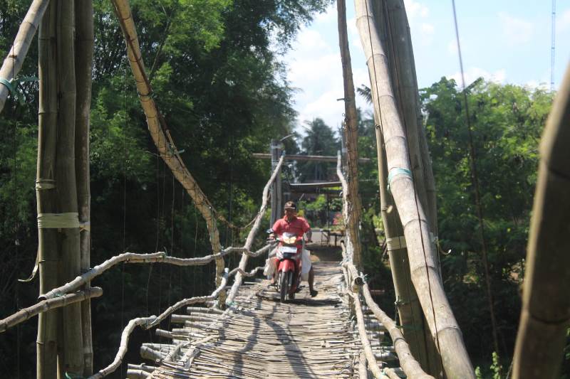 BERBAHAYA: Warga melintasi jembatan gantung yang menghubungkan Dusun Bayatrejo, Desa Wringinpitu, Kecamatan Tegaldlimo dengan Dusun Rumping, Desa Plampangrejo, Kecamatan Cluring Rabu (20/11)