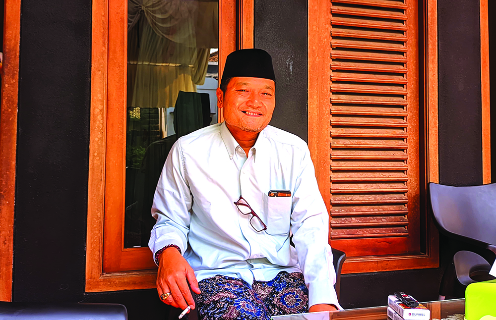 SENYUM SANTAI: Ali Makki terlihat santai di posko kemenangan Dusun Rayud, Desa Parijatah Kulon, Kecamatan Srono, Kamis (28/11).