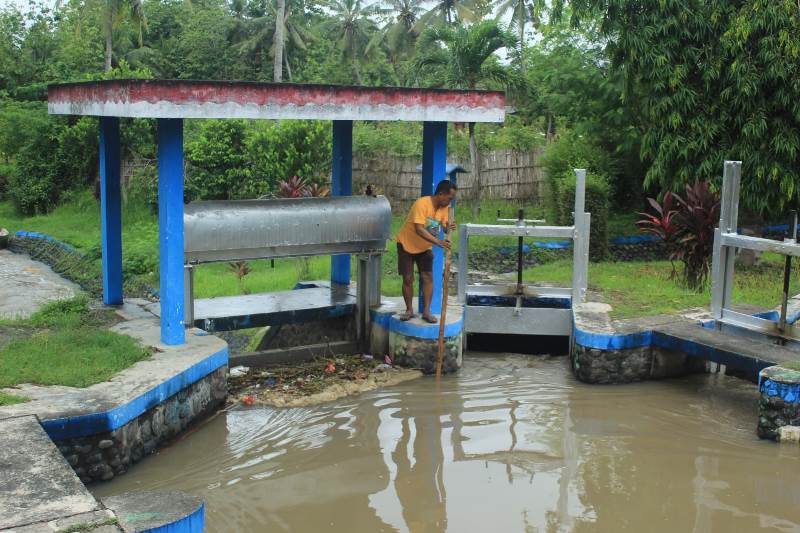 MEMBERSIHKAN: PPA di Korsda Tegaldlimo Fushen Salasa membersihkan sampah yang tersangkut di dam Desa/Kecamatan Tegaldlimo Minggu (1/12).