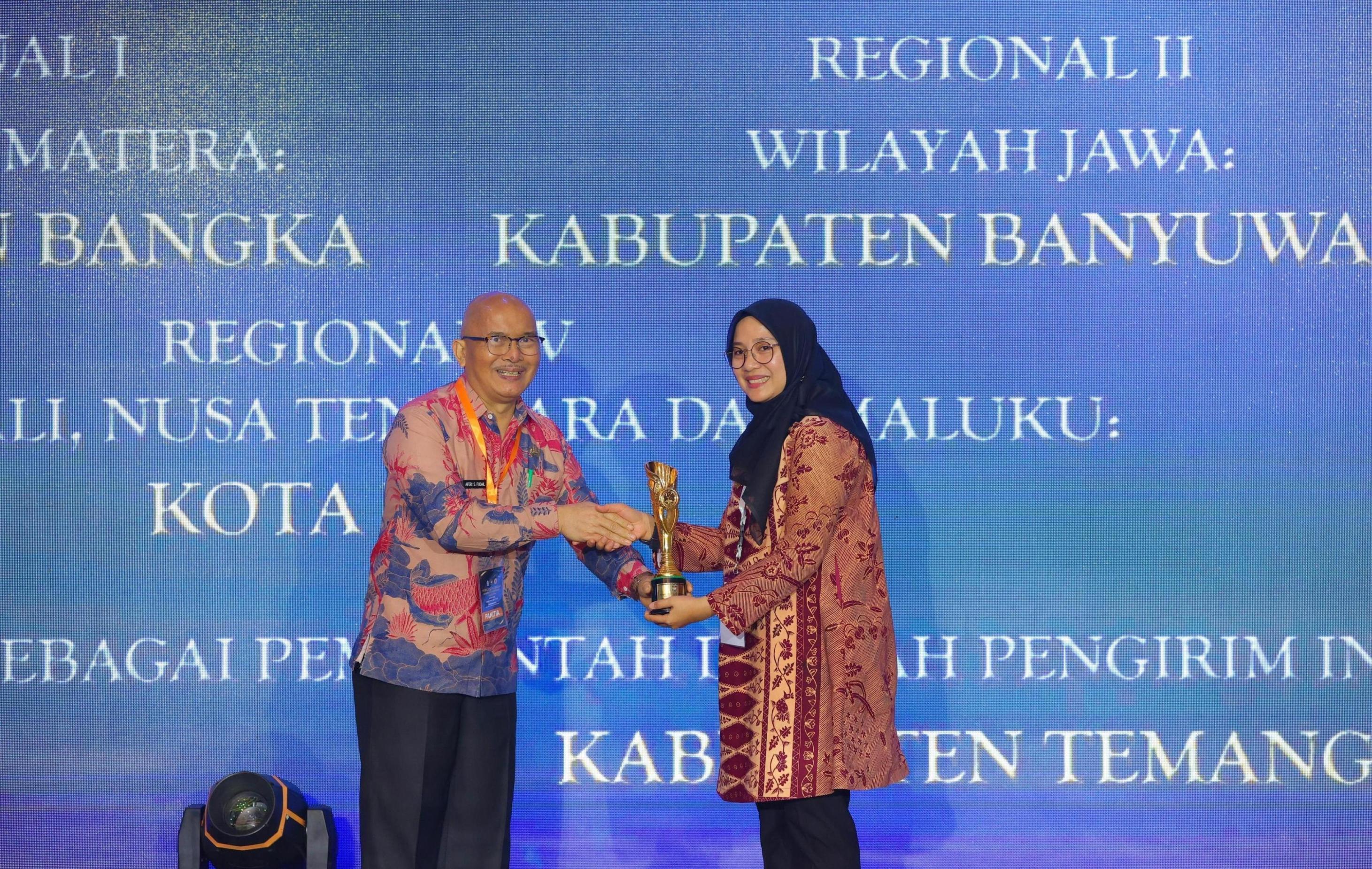 KAYA INOVASI: Bupati Ipuk Fiestiandani menerima piala lambang supremasi kabupaten paling inovatif dari Kepala BKSDN Kemendagri Yusharto Huntoyungo di Surabaya Kamis (5/12).