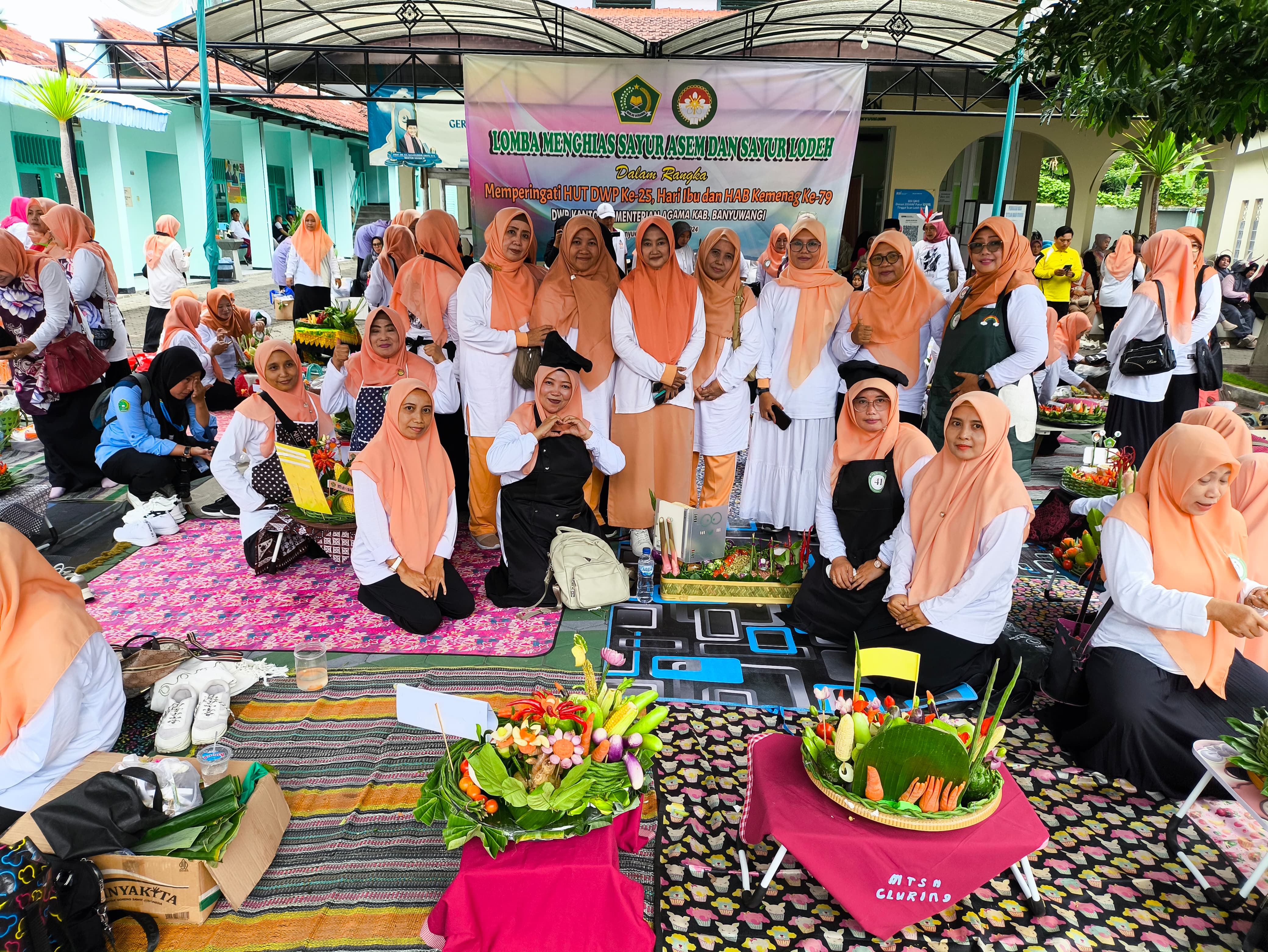 Ketua DWP Kantor Kemenag Banyuwangi Nyonya Siti Qudsiyah Chairono Hidayat (tengah) berfoto bersama peserta lomba menghias bahan sayur asam dan lodeh di halaman belakang Kantor Kemenag Banyuwangi.