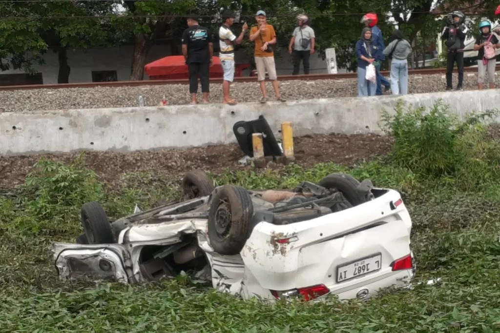 Mobil Daihatsu Xenia rusak parah dan terbalik usai menemper Kereta Api Sri Tanjung di petak jalur antara Stasiun Rejoso dan Pasuruan, Rabu siang (11/12).