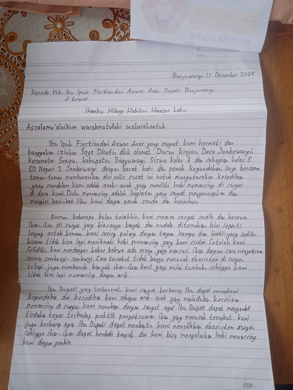 Surat yang ditulis Dhofin dkk untuk Bupati Ipuk Fiestiandani, karena sering tidak dapat ikan saat memancing.
