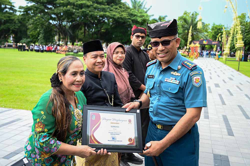 Sumiati menerima penghargaan dari Pemkab Banyuwangi yang diserahkan oleh Danlanal Banyuwangi Letkol Laut (P) Hafidz  pada puncak peringatan Harjaba ke-253 di Taman Blambangan (18/12).