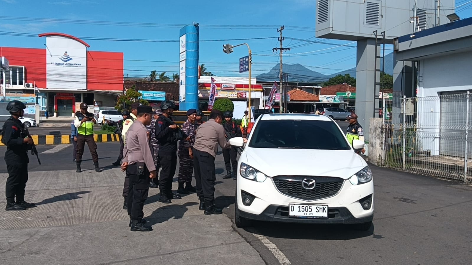JAGA KELANCARAN: Personel Polresta Banyuwangi dikawal anggota Brimob dan TNI memeriksa surat-surat kendaraan di pintu masuk Pelabuhan ASDP Ketapang, Senin (23/12).