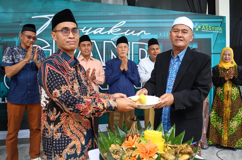 KESEHATAN: Pengasuh Pondok Pesantren Darussalam, Blokagung KH Ahmad Hisyam Syafaat menyerahkan potongan tumpeng tanda peresmian Klinik Assyifa kepada Pimpinan Klinik Assyifa KH Abdul Kholiq Syafaat.