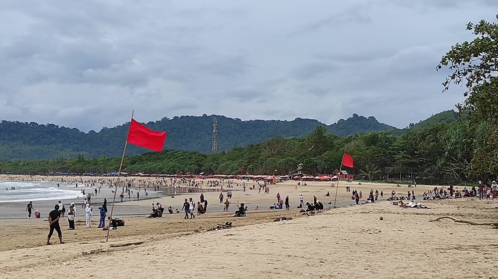 MENYEMUT: Destinasi wisata Pantai Pulau Merah dipadati ribuan pengunjung saat merayakan tahun baru, Rabu (1/1).