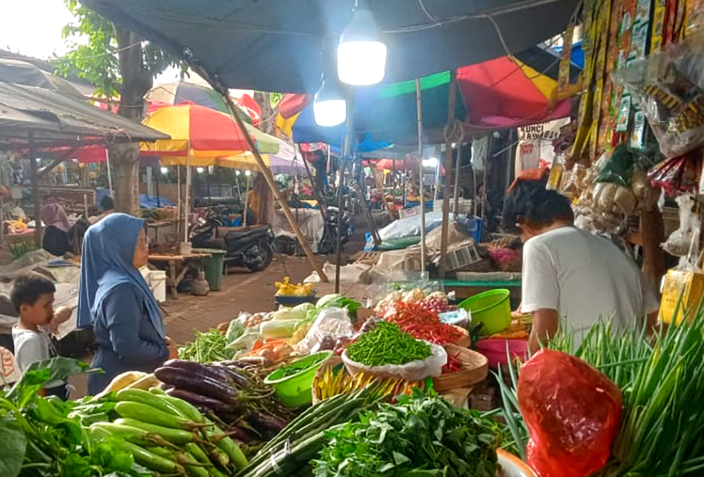 BERJUALAN: Diko menjajakan aneka bumbu dan sayuran di Pasar Banyuwangi, Minggu (5/1).