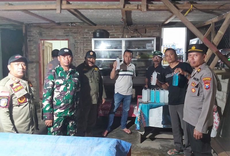 RAZIA: Tim gabungan di Kecamatan Pesanggaran menunjukkan miras hasil operasi yang dilakukan di Desa Sumberagung, dan Desa Kandangan, Kecamatan Pesanggaran Rabu (8/1).