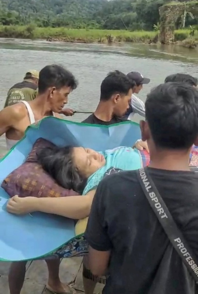 MENEGANGKAN: Eliswatin asal Dusun Sukamade, Desa Sarongan, Kecamatan Pesanggaran digotong warga menyeberangi Sungai Sukamade dengan naik Gethek menuju RSUD Genteng untuk persalinan
