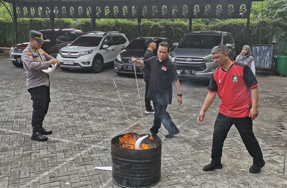 BAKAR HABIS: Petugas Dinas Pendidikan Banyuwangi bersama Polresta Banyuwangi memusnahkan ribuan blangko ijazah rusak di halaman belakang kantor Dispendik pada Jumat (10/1).