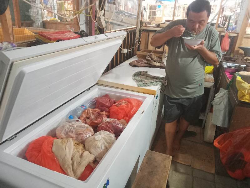 MEMAMERKAN: Salah satu penjual daging sapi di Pasar Banyuwangi, Dollah menunjukkan daging sapi di lapaknya pada Senin (13/1).