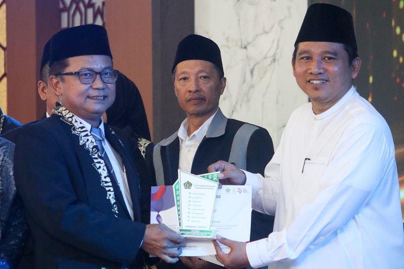TERBAIK: Dewan pengasuh PP Mabadiul Ihsan Desa Karangdoro, Tegalsari KH Rohmatullah Dimyati menerima Kemangi Award 2025 menjadi yang terbaik dalam Eco Pesantren dari Kepala Kemenag Banyuwangi.