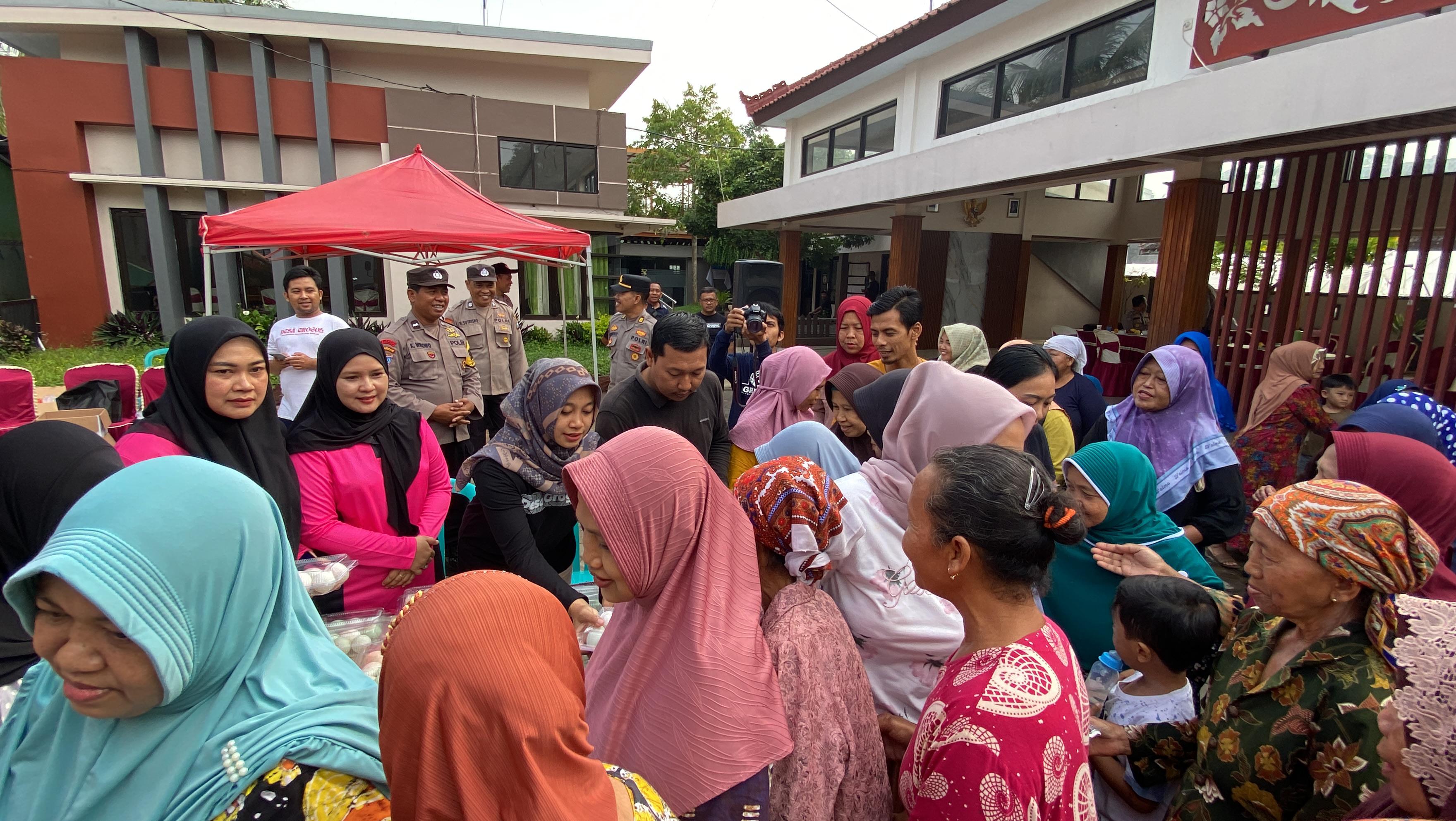 Warga Grogol berebut sayur mayur yang dibagikan Sat Binmas Polresta Banyuwangi, Jumat (17/1/25).