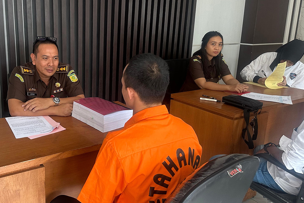 PAKAI SERAGAM TAHANAN: Guru honorer asal Gambiran yang kesandung kasus tindak pidana siber, Barik Abdul Ghofur, dilimpahkan ke Kejari Banyuwangi Jumat (17/1).