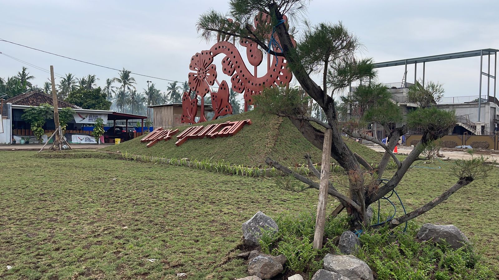 USUNG KEARIFAN LOKAL: Signage berupa batik Gajah Oling terpasang di arena sirkuit BMX Muncar. Kanan kirinya ditanami rumput dan cemara udang.