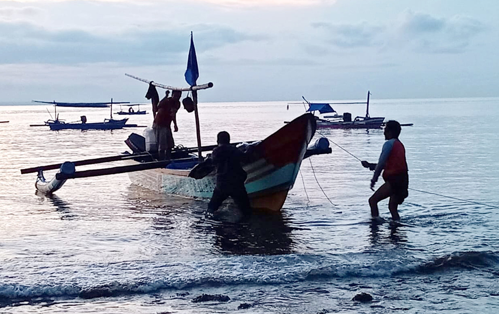 RUTIN: Awak kapal nelayan &lsquo;Bang Jampang&rsquo; bongkar muatan koran Jawa Pos di Pantai Bulusan, Kecamatan Kalipuro, Banyuwangi.