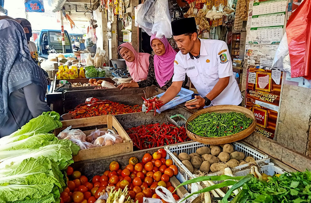 CEK: Petugas Pasar Induk Genteng 1, Desa Genteng Kulon, Kecamatan Genteng Arif Kurniawan memantau harga cabai di pedagang pasar, Jumat (24/1).