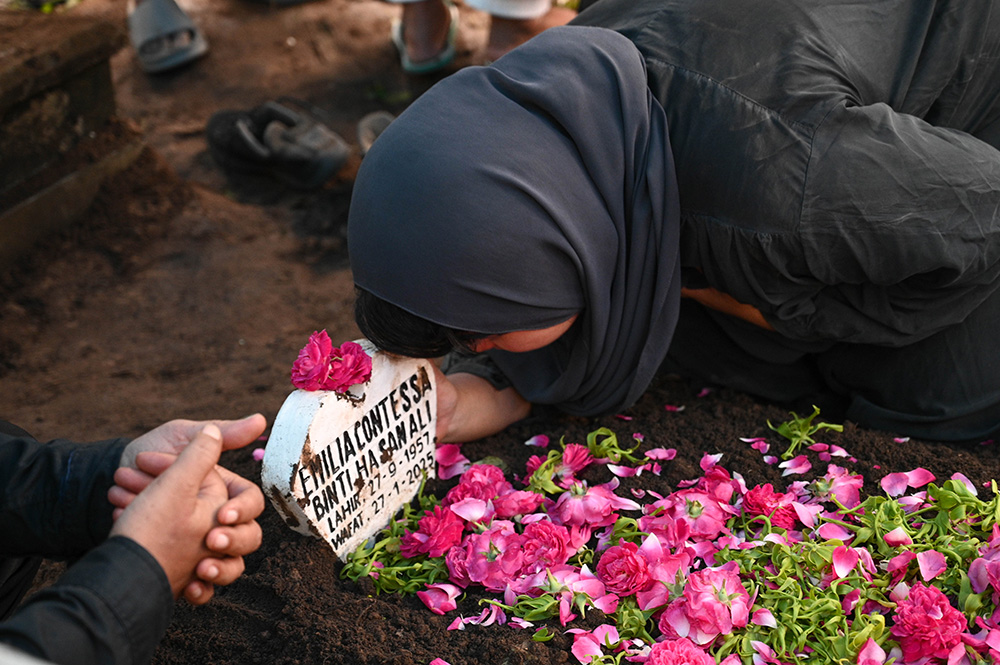 BERDOA: Salah satu kerabat dekat Emilia Contessa memeluk pusara sebelum meninggalkan makam di TPU Penganjuran Banyuwangi, Selasa (28/1).