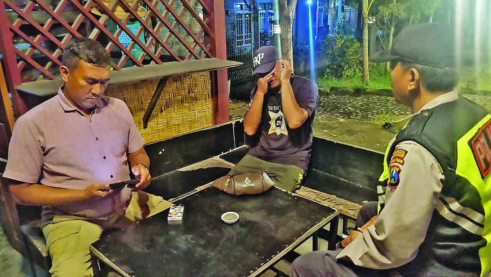 KEKELUARGAAN: Angga Yandi (tengah) saat diamankan anggota Polsek Purwoharjo pada Kamis, (30/1) malam.