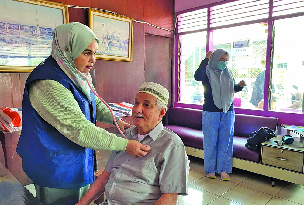 CEK TENSI: dr Syifa Mustika SpPD-KGEH Finasim memeriksa pasien pada baksos yang digelar Sabtu (8/2).
