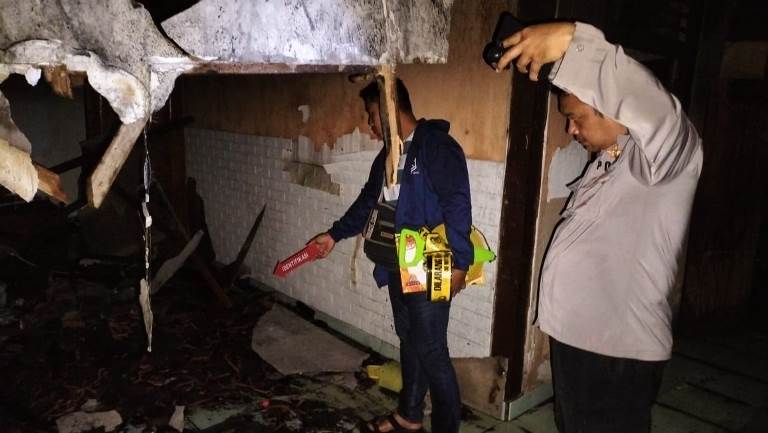 PADAM: Anggota Polsek Tegaldlimo saat memeriksa rumah pegawai PLN Muncar Latif Hamdani di Dusun Sumberkepuh, Desa Kedungwungu, Kecamatan Tegaldlimo yang terbakar pada Minggu (9/2) petang.