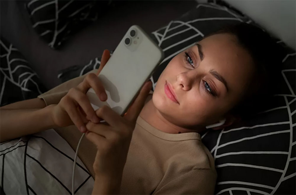 ilustrasi orang yang bermain handphone kala waktu tidur.