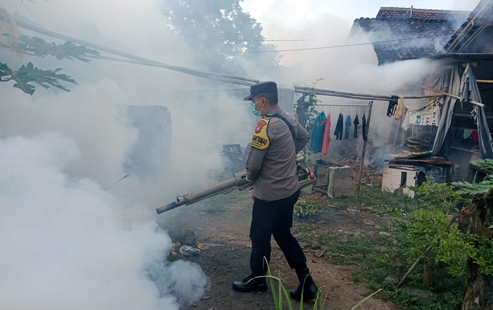PENGASAPAN: Anggota polisi dari Polsek Srono melakukan fogging di Dusun Krajan, Desa Kebaman, Kecamatan Srono Jumat (14/2).