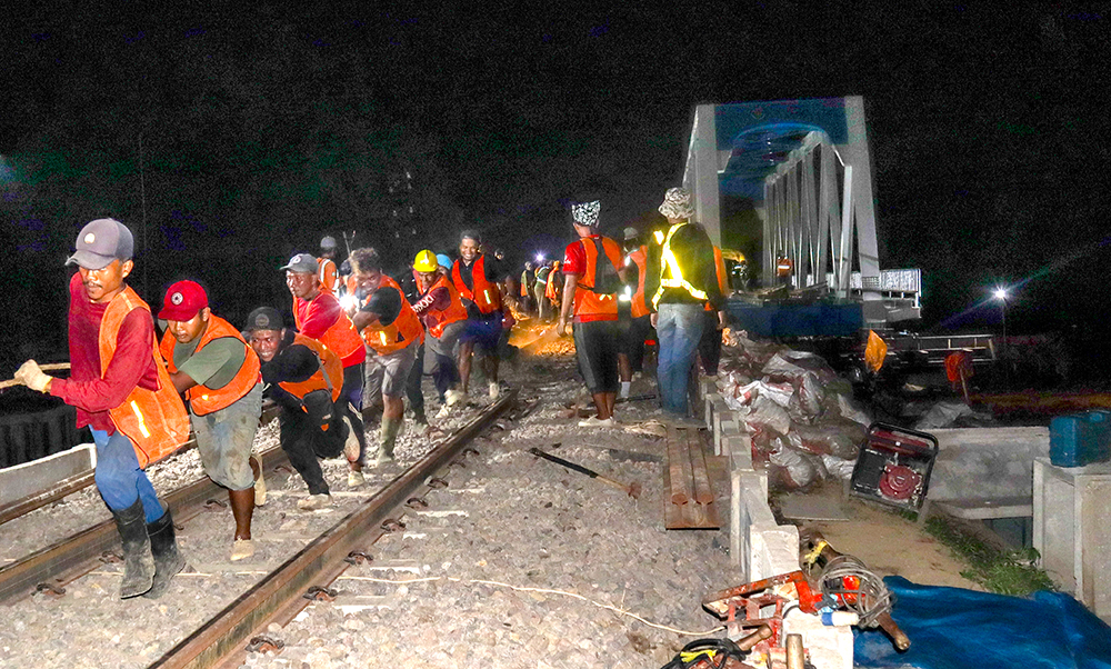 Para pekerja dari BTP Kelas I Surabaya saat proses pemindahan jembatan sepur baru di Dusun Tegalmojo, Desa Gumirih, Singojuruh, Banyuwangi, Jumat dini hari (14/2).