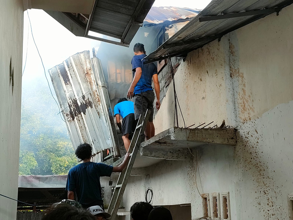 Warga memadamkan api yang membakar rumah Haryono di Dusun Balak Kidul, Desa Balak, Songgon pada Kamis (13/2) sore menggunakan alat seadanya.