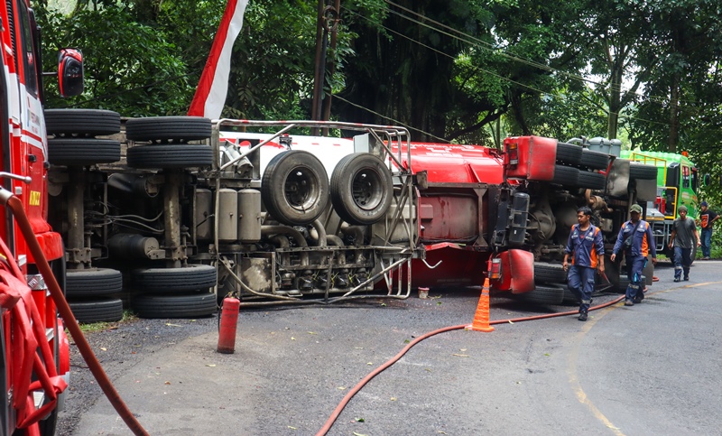 TERGULING: Truk tangki muatan BBM terguling di Jalan Gumitir pada Rabu (19/2) sore. Sampai Kamis (20/2) sore, evakuasi belum selesai.
